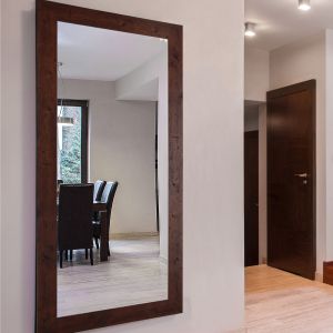 Această oglindă de perete confortabilă completează multe stiluri de decor